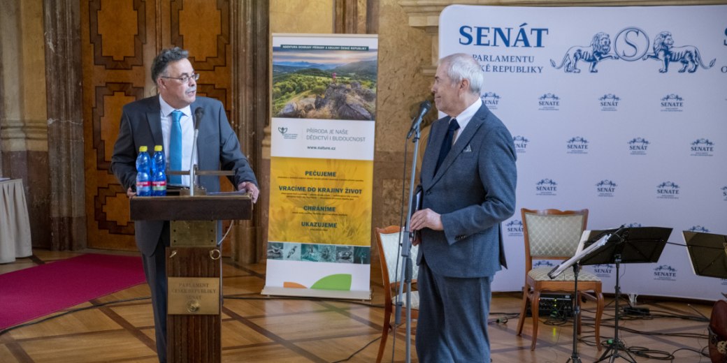 Marek Eben a Jindřich Horáček ze Slavkovského lesa zahajují konferenci v prostorách Valdštejnského sálu. 